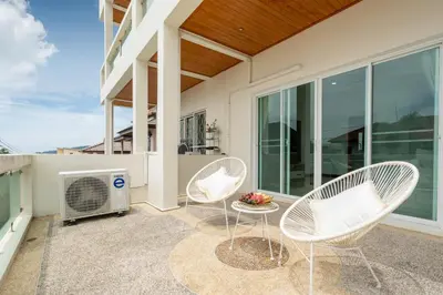 a patio with two chairs and a heater on a balcony at Apartment 1 Bedroom in Naiharn t in Ban Saiyuan (1)