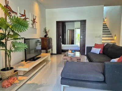 a living room with a couch and a tv at Oxygen Condominium Bangtao in Ban Thalat Choeng Thale