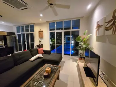 a living room with a couch and a table at Oxygen Condominium Bangtao in Ban Thalat Choeng Thale