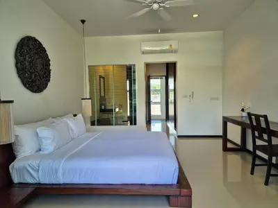 a bedroom with a white bed and a desk at Oxygen Condominium Bangtao in Ban Thalat Choeng Thale