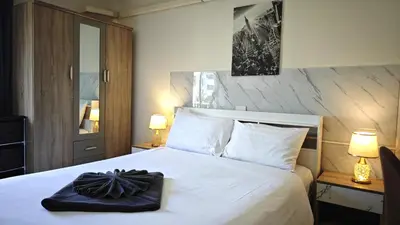 a bedroom with a bed with a black purse on it at Apartments Kata Beach view garden in Kata Beach