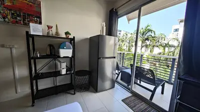 a kitchen with a refrigerator and a balcony at Apartments Kata Beach view garden in Kata Beach