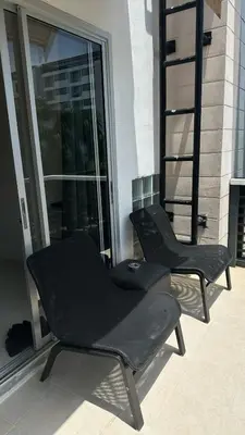 two black chairs sitting on the side of a building at Apartments Kata Beach view garden in Kata Beach