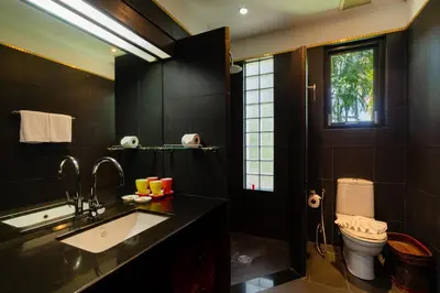 a black bathroom with a sink and a toilet at Baan Mandala Villa 4 in Bang Tao Beach
