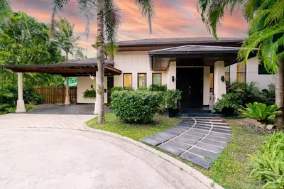 a house with palm trees and a driveway at Baan Mandala Villa 4 in Bang Tao Beach