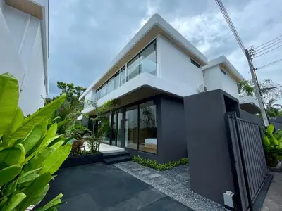 a white house with glass windows and plants at Grand Villa Aileen in Nai Yang Beach