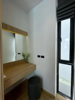 a dressing room with a mirror and a black stool at Grand Villa Aileen in Nai Yang Beach