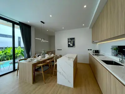 a kitchen and dining room with a table and a counter at Grand Villa Aileen in Nai Yang Beach