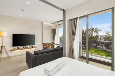 a bedroom with a bed and a couch and a tv at Laguna Lakeside BangTao by My Home Phuket in Bang Tao Beach