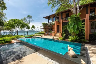 an outdoor swimming pool in front of a house at Villa Viva Panwa in Ban Laem Phan Wa