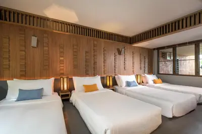 three beds in a room with wooden walls at Villa Viva Panwa in Ban Laem Phan Wa