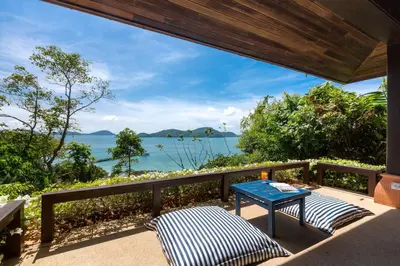 a balcony with a table and a view of the ocean at Villa Viva Panwa in Ban Laem Phan Wa