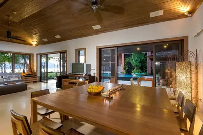 a living room with a large wooden table with chairs at Villa Viva Panwa in Ban Laem Phan Wa