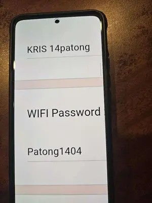a cell phone with a sign that says wifi password at Apartment in Patong Tower in Patong Beach