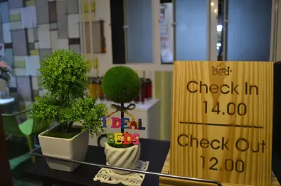 a table with two potted plants next to a sign at iDeal Beds Hostel Ao Nang Beach in Ao Nang Beach