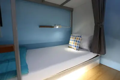 a bed in a room with a pillow on it at iDeal Beds Hostel Ao Nang Beach in Ao Nang Beach