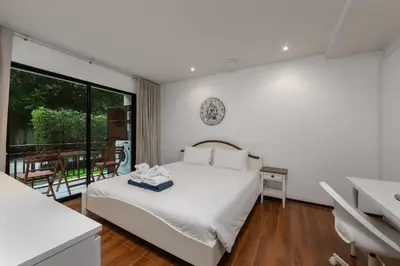 a white bedroom with a bed and a balcony at Renovated apartment in The Title Phase I, Rawai beach in Rawai Beach
