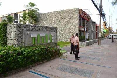 two men standing in front of a building with a sign at Renovated apartment in The Title Phase I, Rawai beach in Rawai Beach
