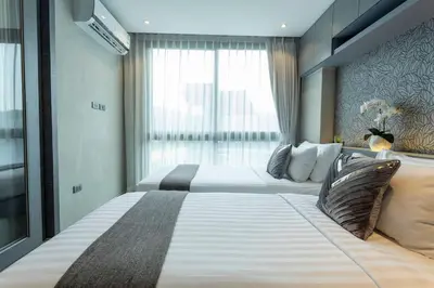 a hotel room with two beds and a window at Best Facilities Fully Loaded Nicest Apartment c138 in Kamala Beach