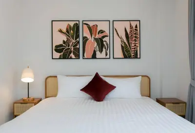 a bedroom with a bed with four pictures on the wall at Wow Academy & Stay Soi Tai-Aed 2A in Ban Suan