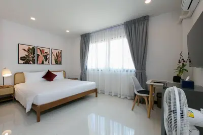 a bedroom with a bed and a desk and a window at Wow Academy & Stay Soi Tai-Aed 2A in Ban Suan