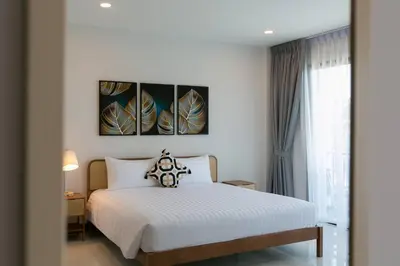 a bedroom with a white bed and three paintings on the wall at Wow Academy & Stay Soi Tai-Aed 2B in Ban Suan
