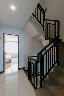 a staircase in a house with a bedroom in the background at Wow Academy & Stay Soi Tai-Aed 2B in Ban Suan