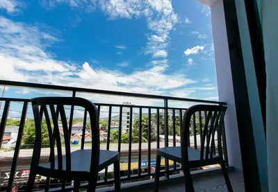 two chairs on a balcony with a view of the ocean at Wow Academy & Stay Soi Tai-Aed 2B in Ban Suan