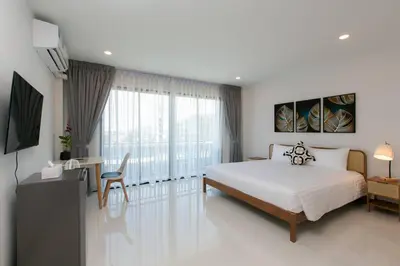 a bedroom with a bed and a desk and a television at Wow Academy & Stay Soi Tai-Aed 2B in Ban Suan