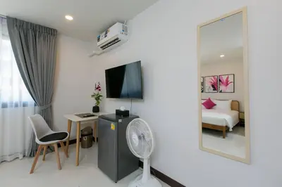 a room with a fan and a bedroom with a bed at Wow Academy & Stay Soi Tai-Aed 3A in Ban Suan