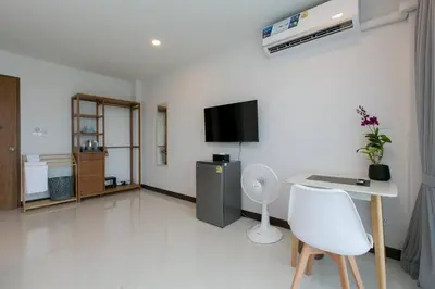a living room with a desk and a tv in a room at Wow Academy & Stay Soi Tai-Aed 3B in Ban Suan