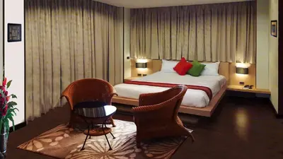 a hotel room with a bed and two chairs at Karon Suite Apartment in Karon Beach