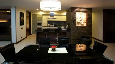 a dining room and kitchen with a table and chairs at Karon Suite Apartment in Karon Beach