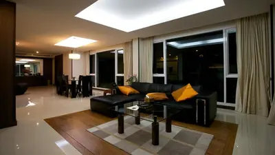 a living room with a black couch and a table at Karon Suite Apartment in Karon Beach