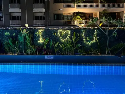 a swimming pool in front of a building with lights at patong v hotel in Patong Beach