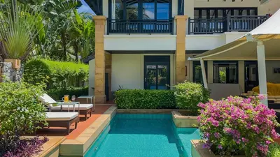 a house with a swimming pool in front of a house at Charming Chom Tawan Villa 3 bdr in Layan Beach