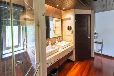 a bathroom with a sink and a large mirror at Charming Chom Tawan Villa 3 bdr in Layan Beach