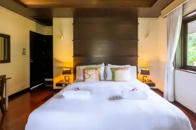 a bedroom with a large white bed with two pillows at Charming Chom Tawan Villa 3 bdr in Layan Beach