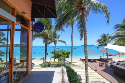 a view of the beach from a resort with palm trees at Bandara Pool Villas, Phuket in Panwa Beach