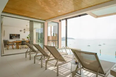 a room with chairs and a view of the ocean at Bandara Pool Villas, Phuket in Panwa Beach