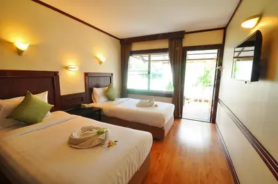 a hotel room with two beds and a balcony at Isle Beach Resort Krabi-SHA in Klong Muang Beach