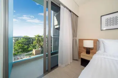 a bedroom with a bed and a large window at New 1 br studio in Laguna Phuket in Phuket Town