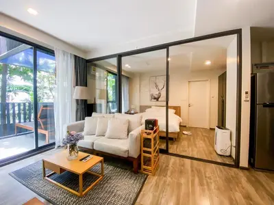 a living room with a couch and a bedroom at The Deck condominium Patong beach in Patong Beach
