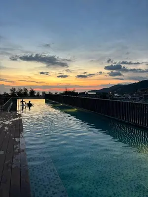a swimming pool on top of a building at sunset at The Deck condominium Patong beach in Patong Beach