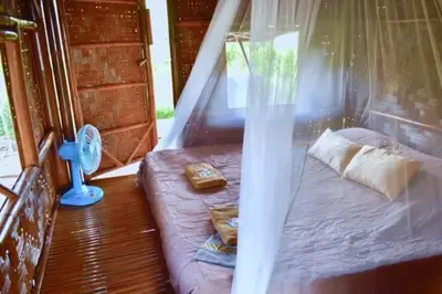a small bed in a room with a window at Micky Monkey Beach Hotel Phuket Maikhao Thailand in Mai Khao Beach