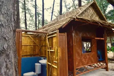 a small bathroom with a toilet and a tree at Micky Monkey Beach Hotel Phuket Maikhao Thailand in Mai Khao Beach