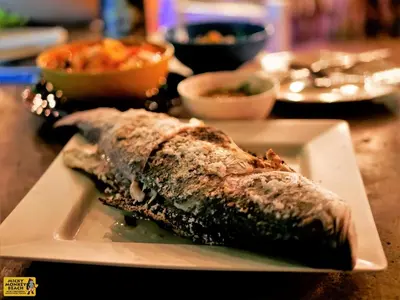 a piece of fish on a plate on a table at Micky Monkey Beach Hotel Phuket Maikhao Thailand in Mai Khao Beach