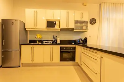 a kitchen with white cabinets and a stainless steel refrigerator at Oxygen 3BR Walk to Shops, Bars, Private Pool v113 in Rawai Beach