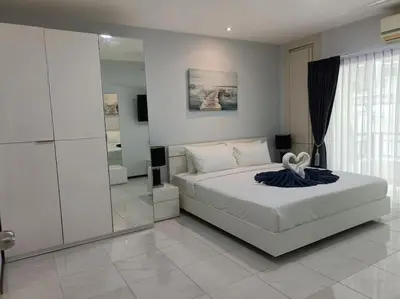 a bedroom with a large white bed and a mirror at Private apartment at Phuket Villa Condo in Patong Beach