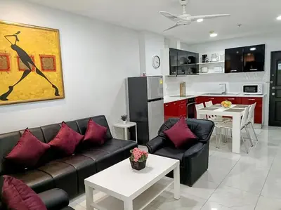 a living room with a couch and a kitchen at Private apartment at Phuket Villa Condo in Patong Beach